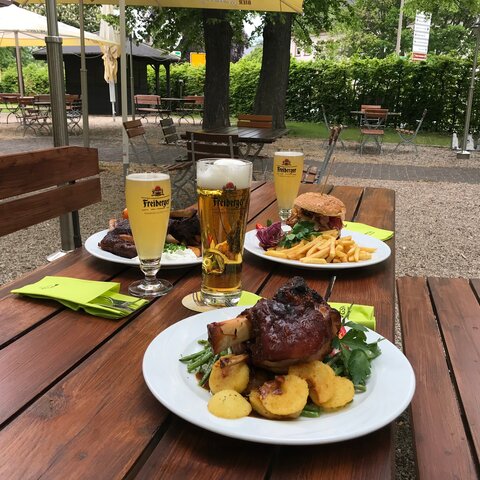 Tisch mit Haxe und Burger sowie Freiberger Pils